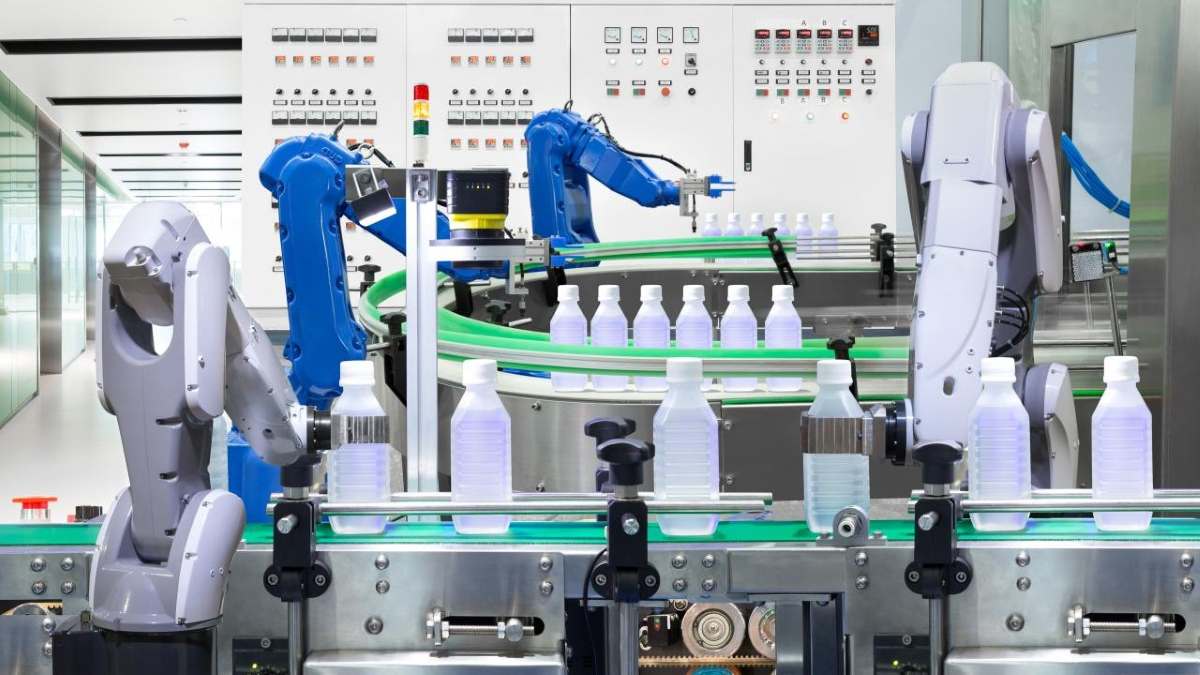 Robots automatizados en una línea de producción de bebidas: La imagen muestra brazos robóticos manipulando botellas en una línea de producción, destacando la eficiencia y precisión de la automatización en la industria alimentaria.